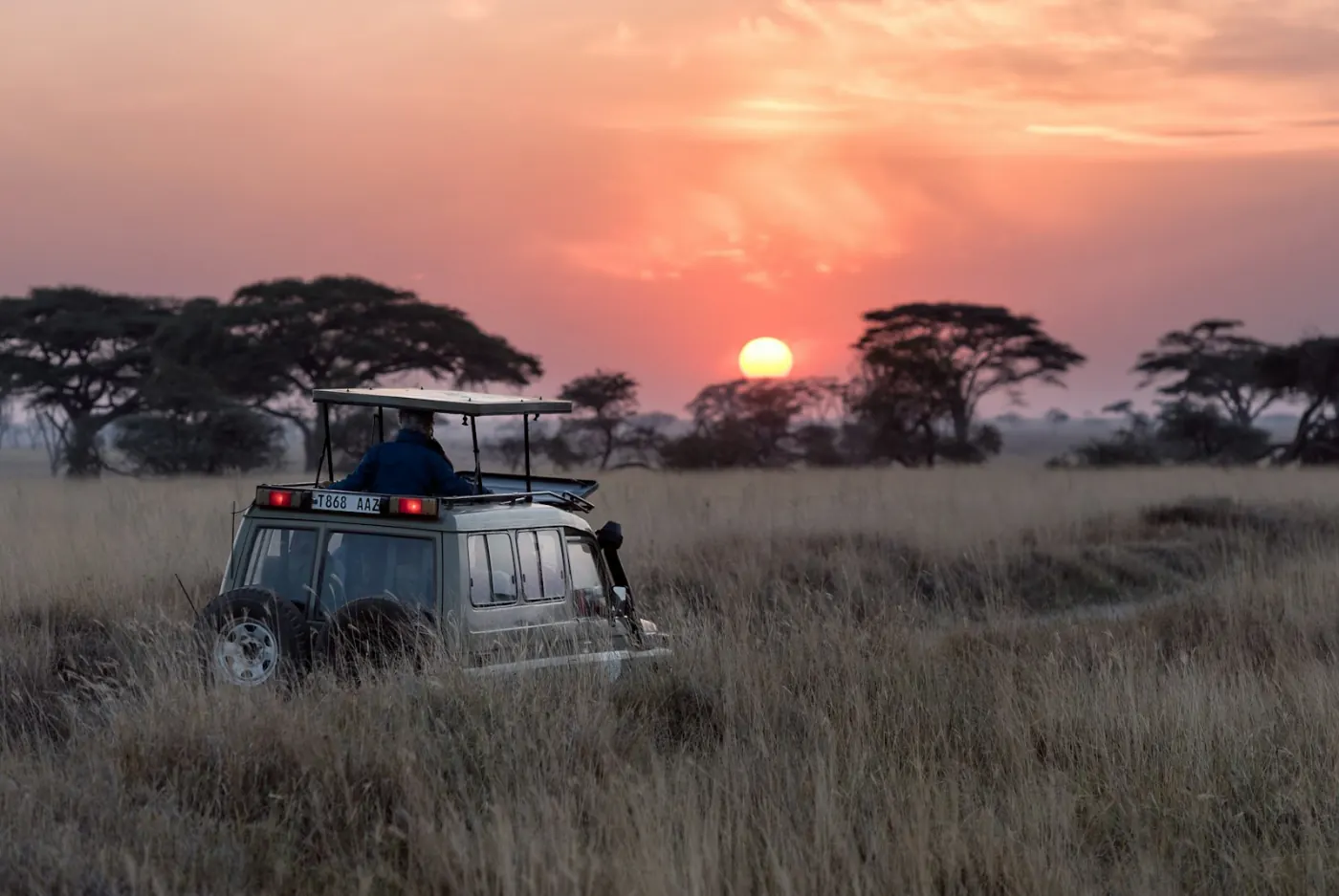 Véhicule de safari dans la savane au Kenya au coucher du soleil, l’un des pays en K