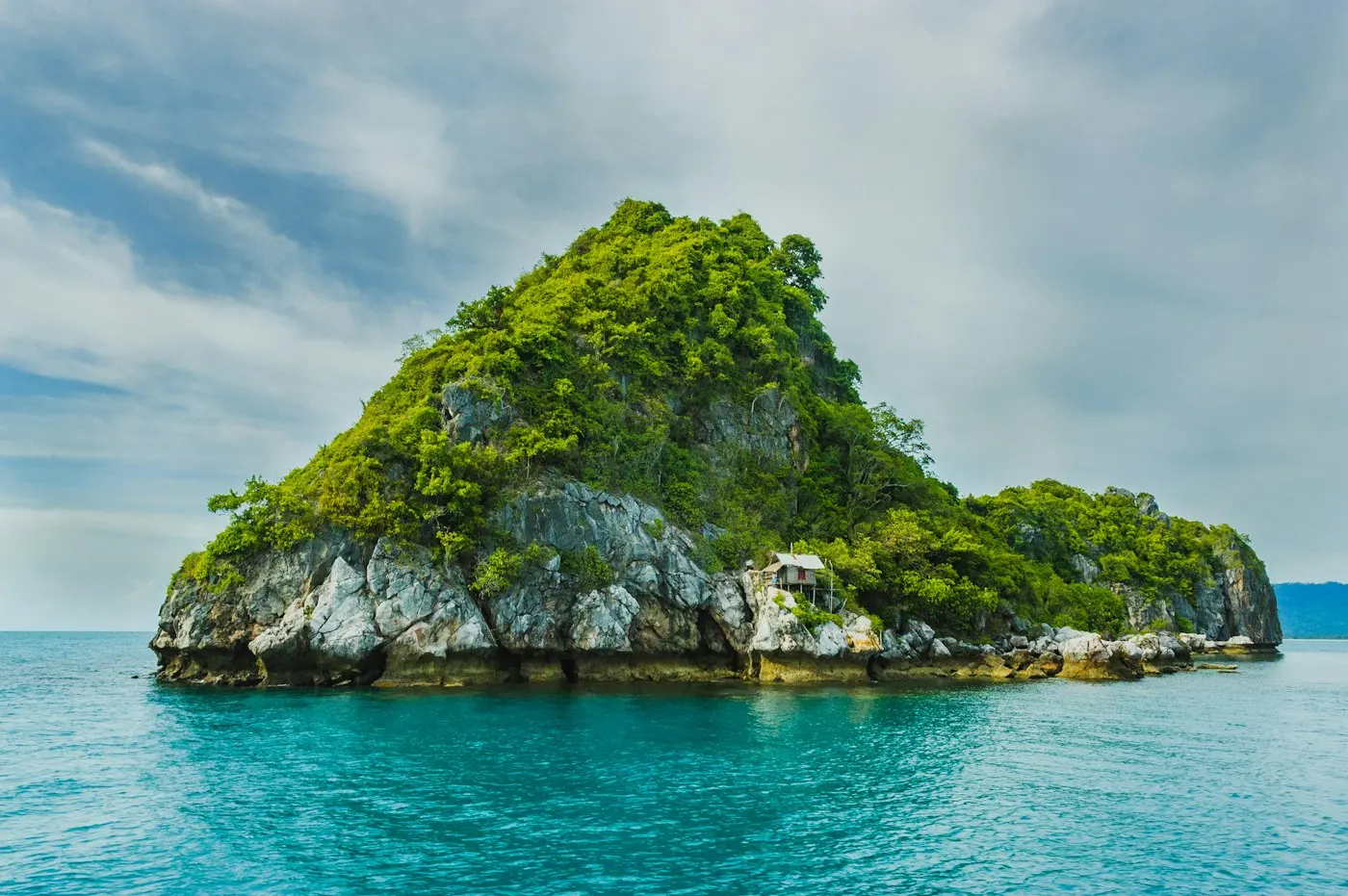 Îlot tropical verdoyant entouré d'eau turquoise, ambiance Pacifique Sud évoquant le Vanuatu