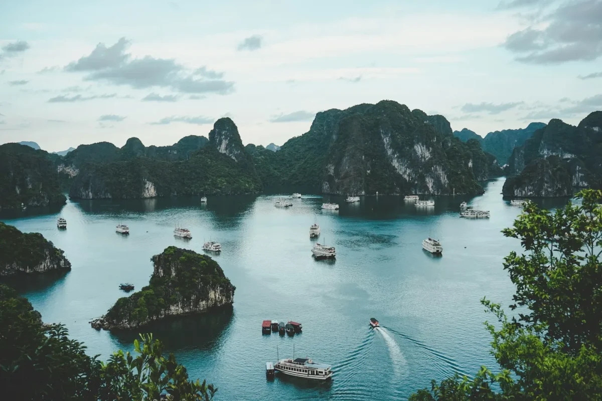 Baie d'Ha Long au Vietnam : pains de sucre calcaires et bateaux sur eau turquoise, illustration des pays en V