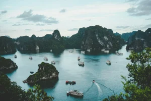 Baie d'Ha Long au Vietnam : pains de sucre calcaires et bateaux sur eau turquoise, illustration des pays en V
