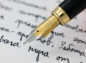 Stylo plume écrivant sur une feuille, illustration de la bonne orthographe de malgré