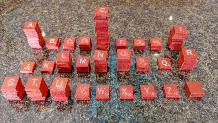 Lettres de Scrabble en français empilées, dont le Q à 8 points, pour trouver un mot avec Q