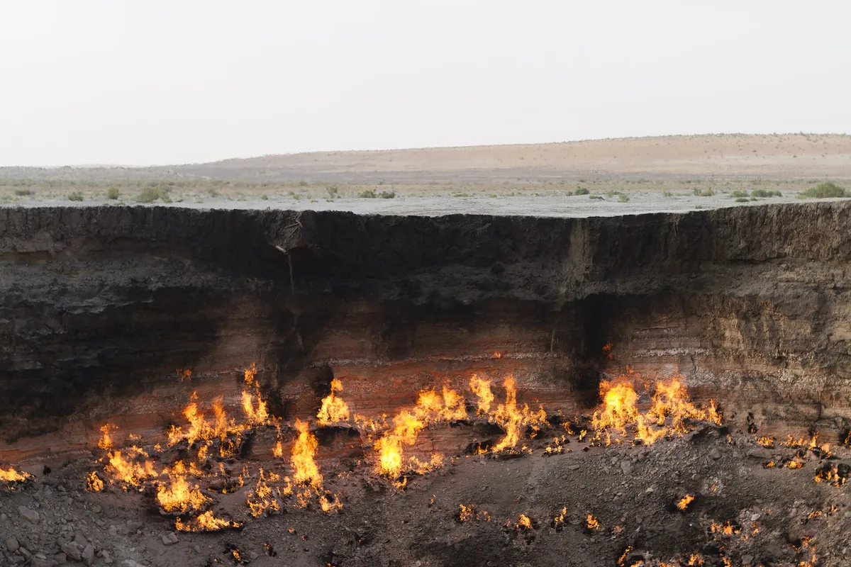 Flammes de gaz brûlant au fond du cratère de Darvaza, dans le désert du Karakoum, au Turkménistan, pays en T