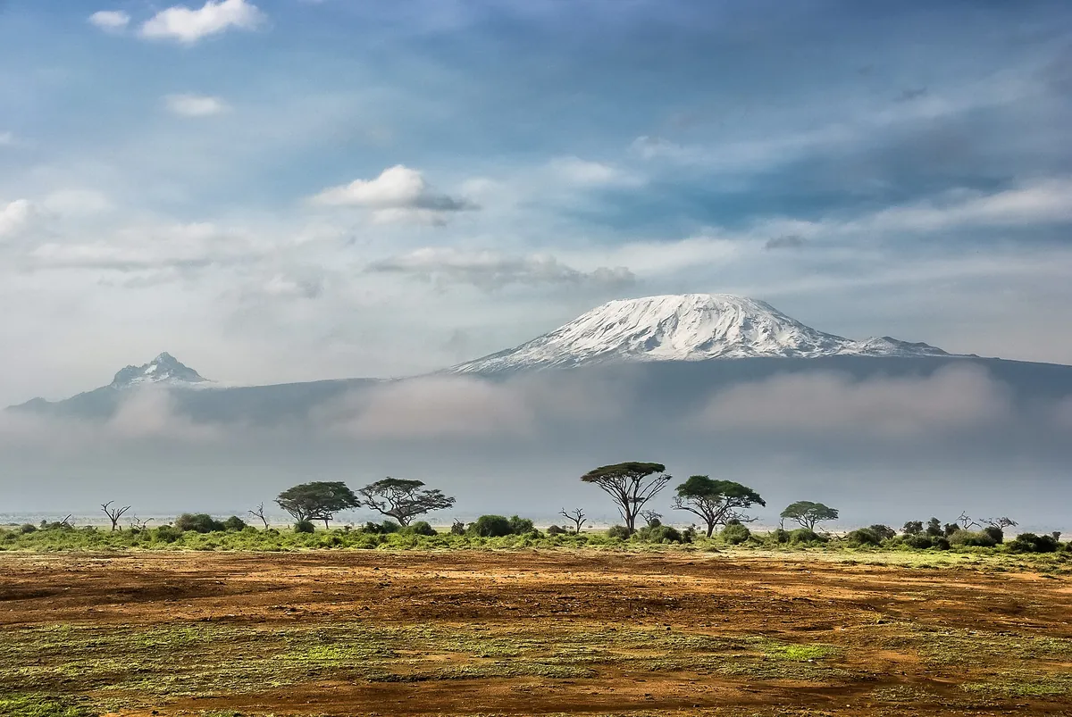 Le Kilimandjaro et son sommet enneigé au-dessus de la savane et des acacias, plus haut sommet d’Afrique, en Tanzanie, pays en T